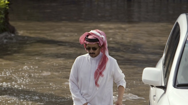A man wades through the floodwaters after heavy rain in Jeddah, Saudi Arabia on November 25, 2009.