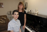 Isaac Graham and mother Jane in front of the piano in their music room