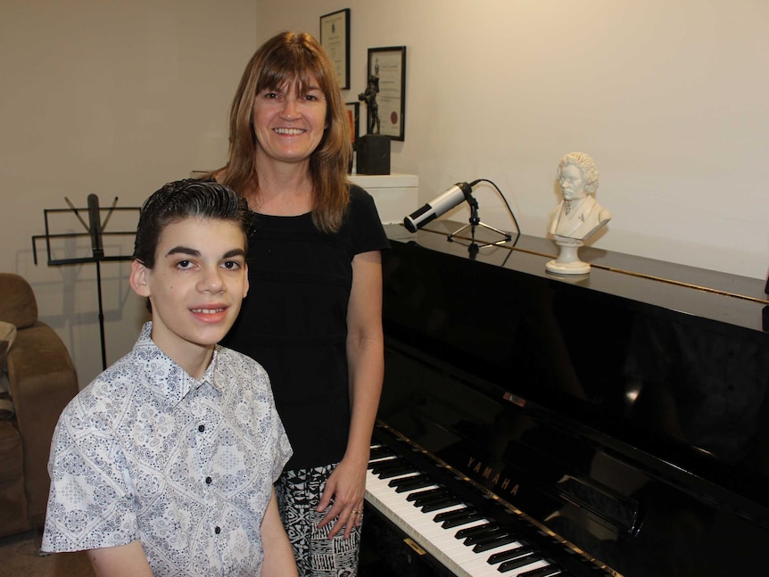 Isaac Graham and mother Jane in front of the piano in their music room