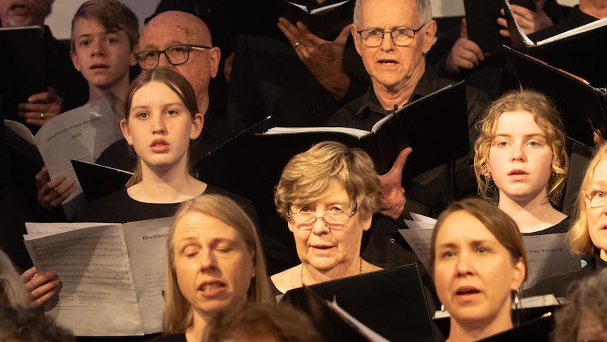 The Blackheath Festival Chorus, a mix of old and young choristers dressed in plain black and holding sheet music.