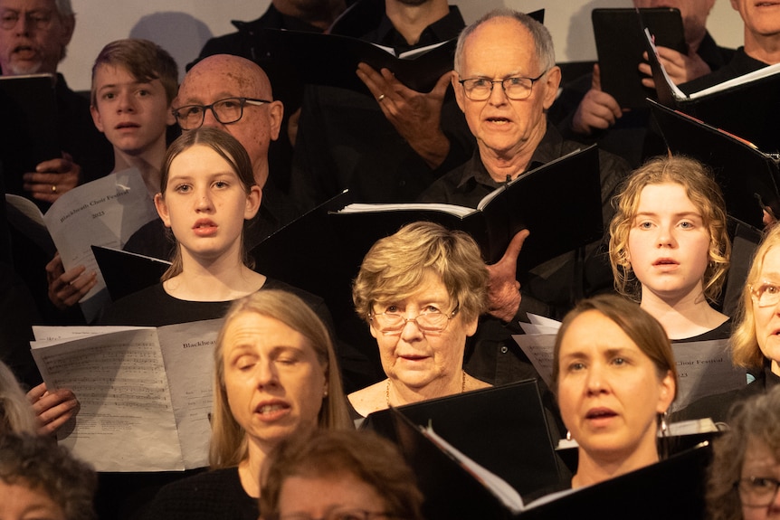The Blackheath Festival Chorus, a mix of old and young choristers dressed in plain black and holding sheet music.