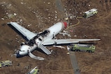 Crashed Asiana Airlines Boeing 777 aircraft surrounded by search and rescue officials