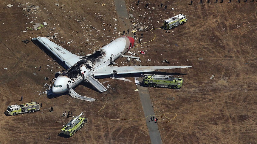 Crashed Asiana Airlines Boeing 777 aircraft surrounded by search and rescue officials