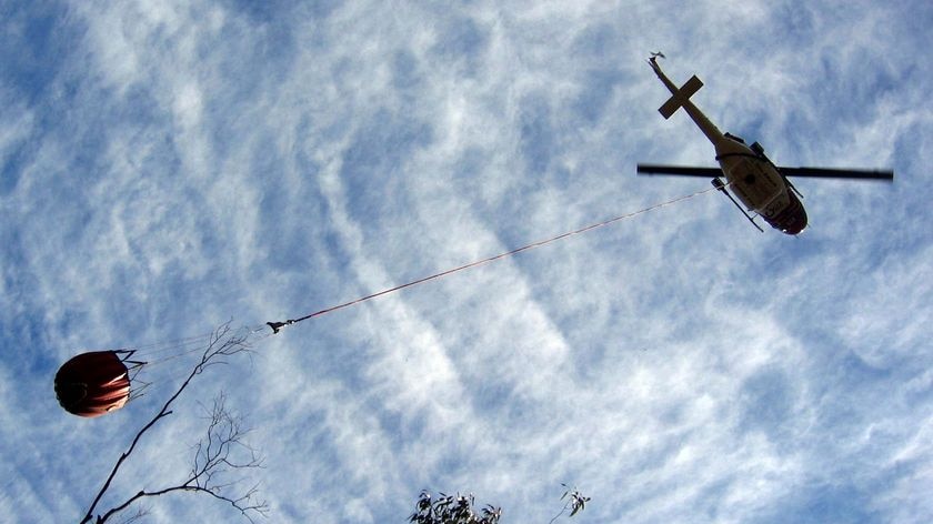 Water bombing helicopter delivers water to a bushfire