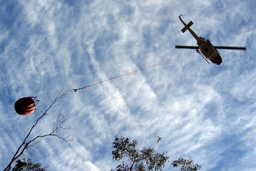 Water bombing helicopter delivers water to a bushfire