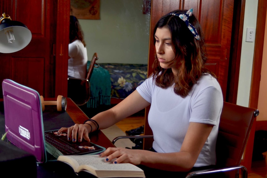 Mayela Dayeh sits at her computer.