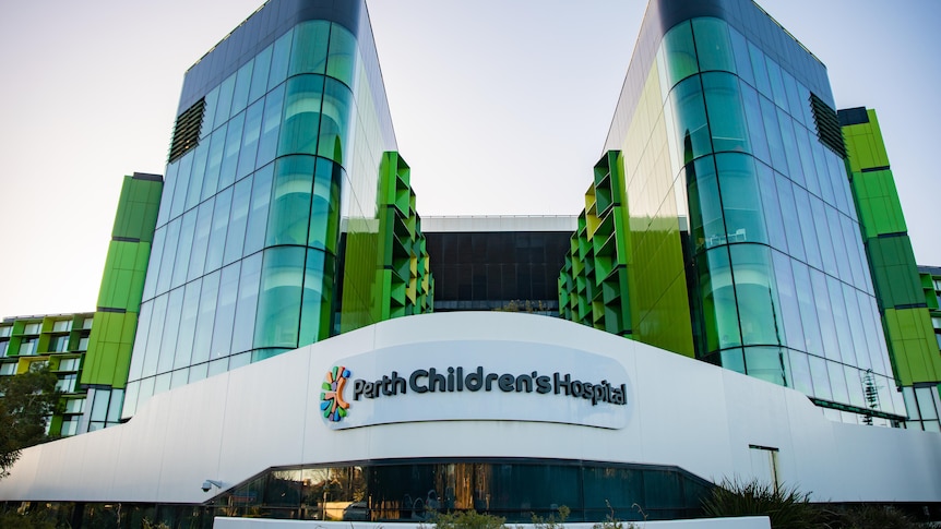 A wide shot of Perth Children's Hospital, showing glass windows and a sign.