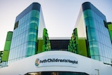 A wide shot of Perth Children's Hospital, showing glass windows and a sign.
