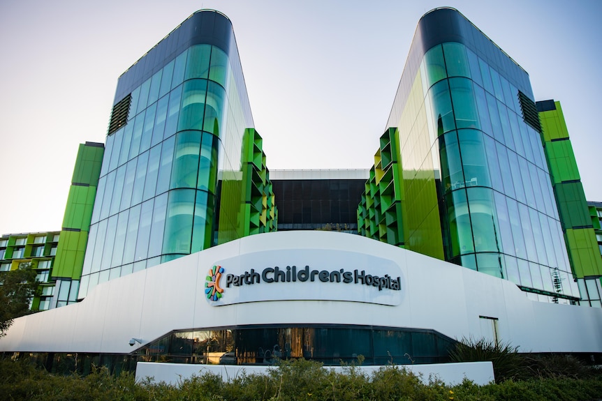 A wide shot of Perth Children's Hospital, showing glass windows and a sign.