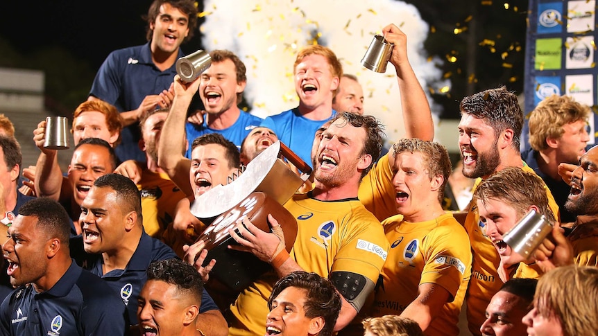 Winners are grinners ... Brisbane City captain Dave McDuling holds up the NRC trophy