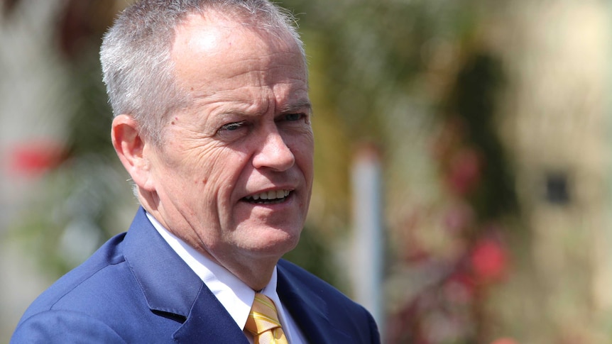 A tight head and shoulders shot of a smiling Bill Shorten outdoors.