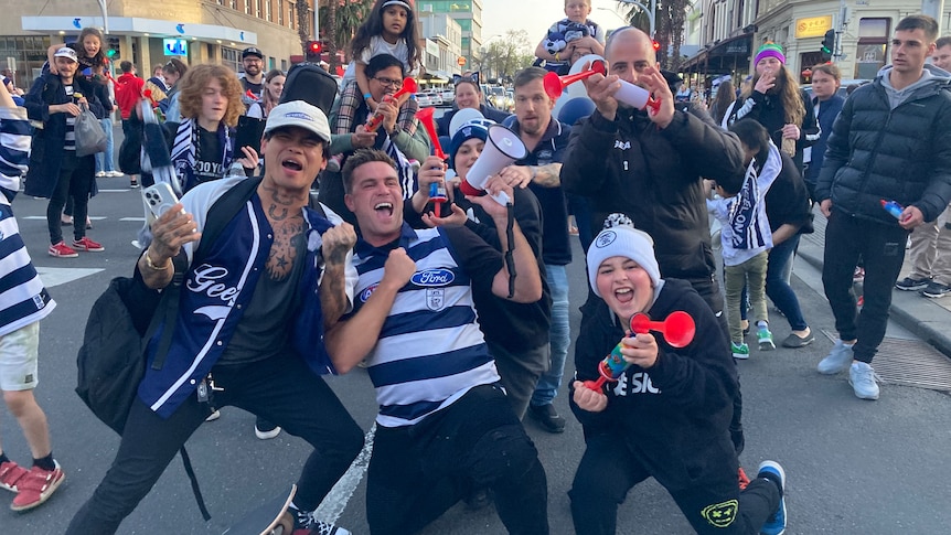 Football fans celebrating in a city street.