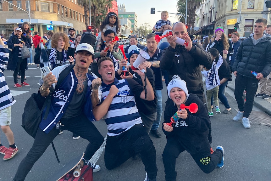 Football fans celebrating in a city street.