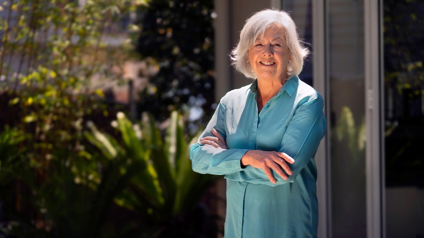 A lady with a teal shirt looking at camera smiling