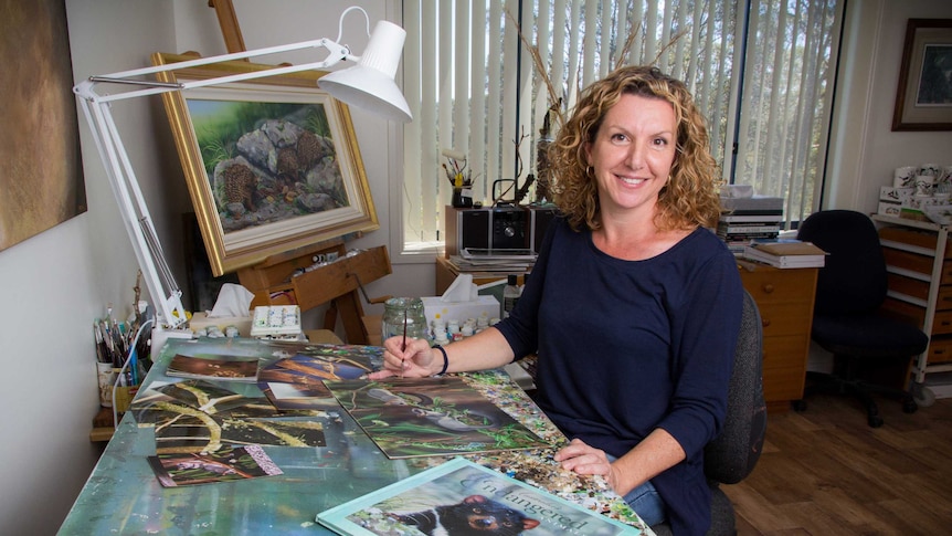 Natalie Parker sits at a bench in her studio.