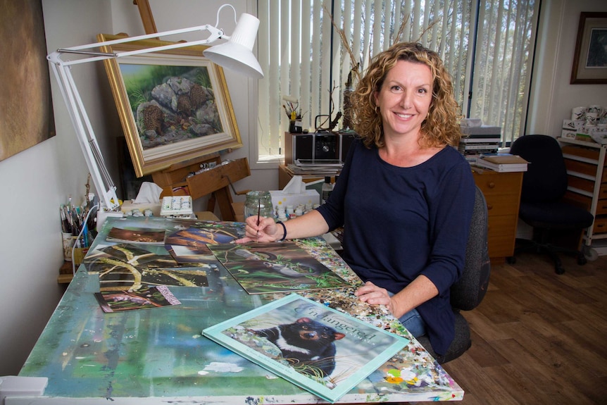 Natalie Parker sits at a bench in her studio.