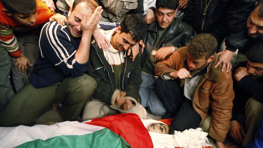 Palestinians mourn next to the body of a boy after he was killed by Israeli forces in Gaza.