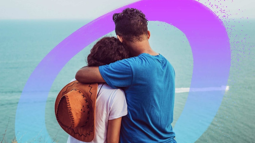 A man and a woman embrace while looking out to sea for a story about how to support someone when they're anxious.