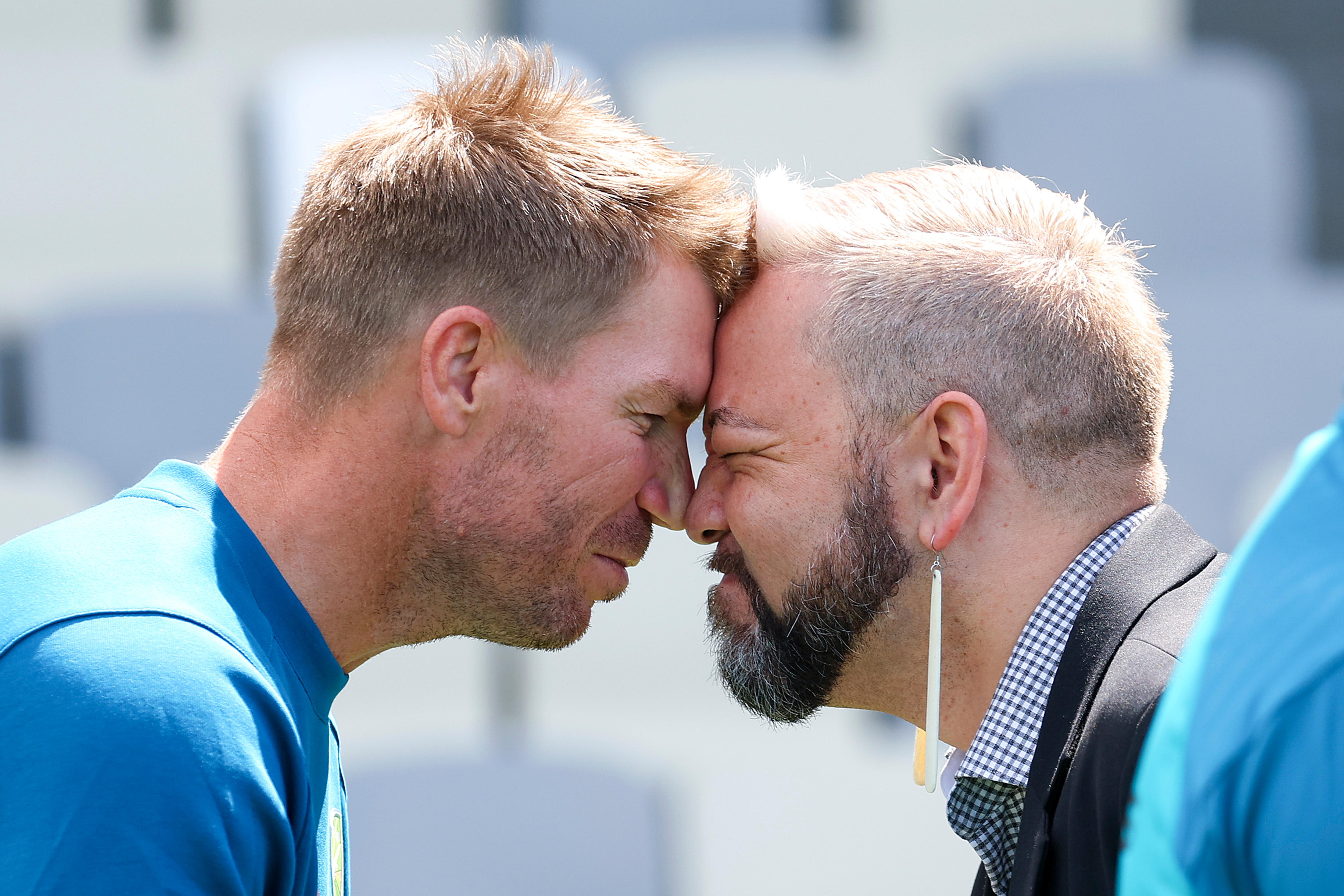 David Warner and another man perform a hongi, with their foreheads touching
