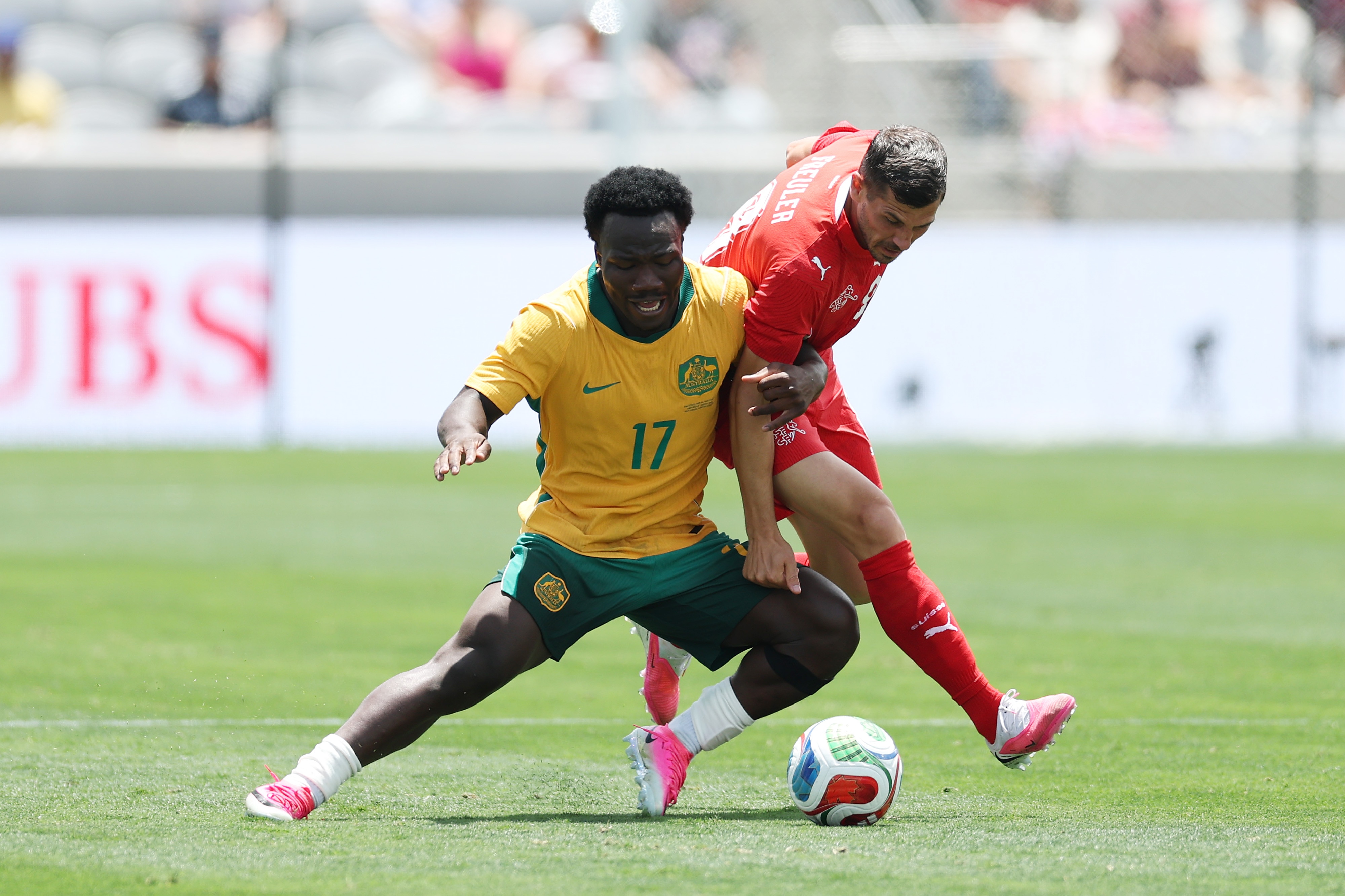 Nestory Irankunda battles a Swiss defender on the ball