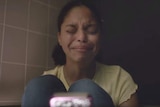A girl cries with eyes closed in a scene from an anti-school-shooting PSA.