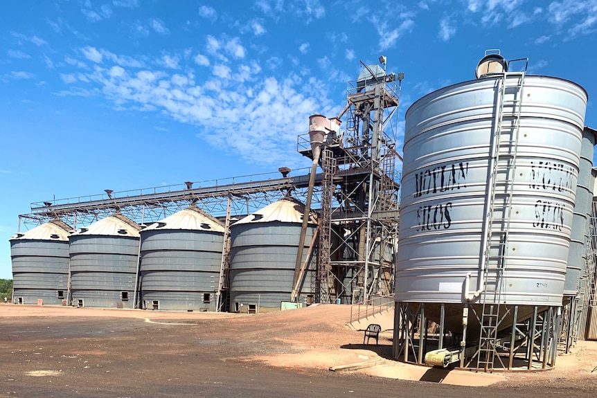 A row of metal silos under the blue sky