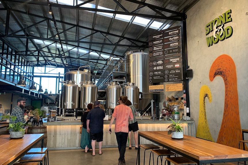 Inside the Stone and Wood brewery with a bar and beer tanks.