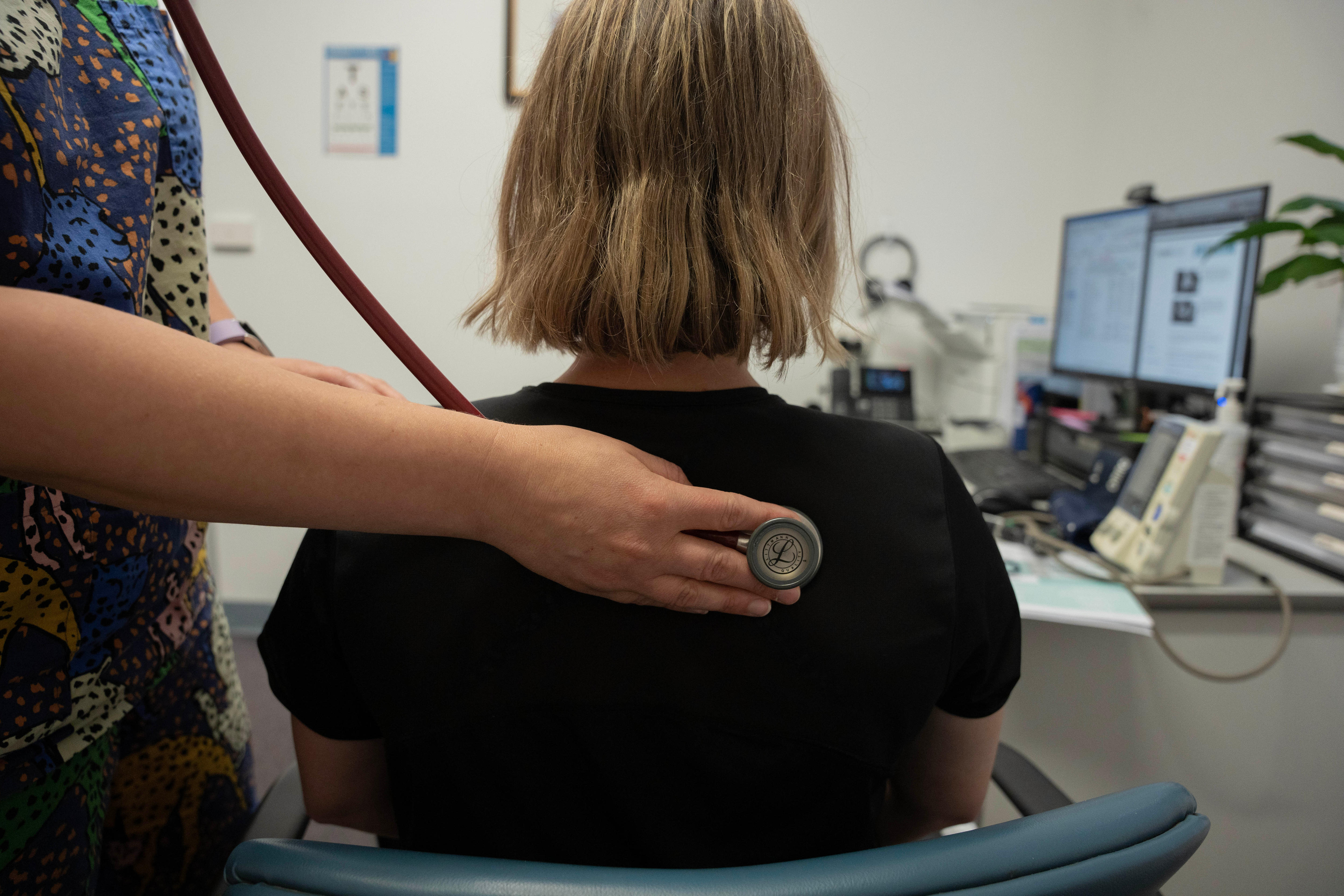 A doctor using a stethoscope on a patient.&nbsp;