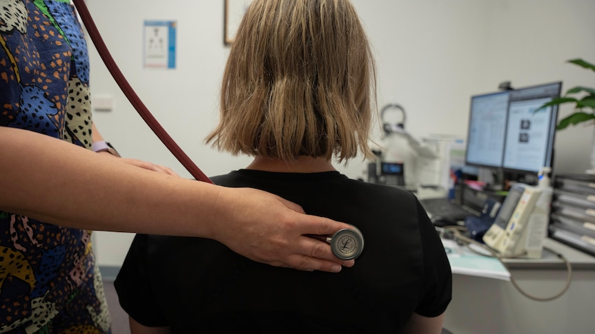 A doctor using a stethoscope on a patient. 