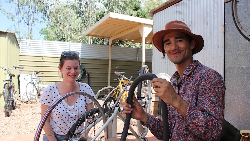 Bethany Wilson gets her bike repaired by Nicholas Smith at the Recycle Cafe.