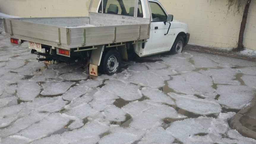 Ice sheets in car park, where a ute is parked.
