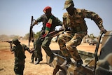 Soldiers jump from a vehicle in Juba