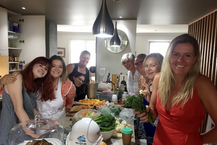 A family prepare Christmas lunch in a kitchen.