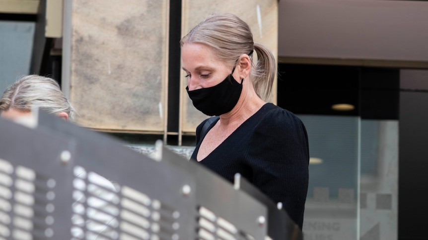 Renee Ferguson, wearing a black face mask, walks outside court.