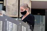 Renee Ferguson, wearing a black face mask, walks outside court.