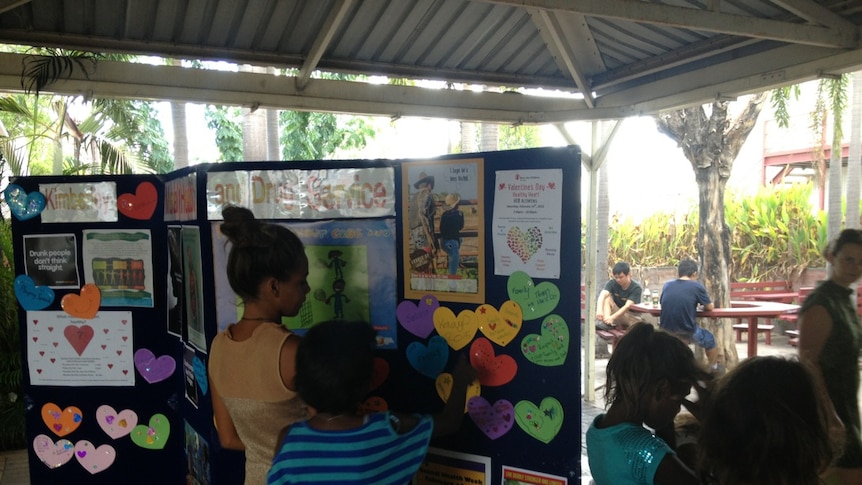 Four children look at health posters on a board in Kununurra in Western Australia's Kimberley.
