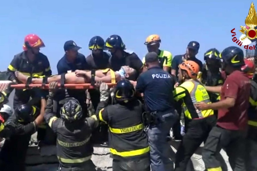 Rescuers carry a young boy on a stretcher.