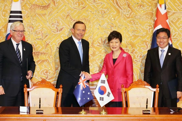 The leaders shake hands and smile for the cameras, flanked by their trade ministers