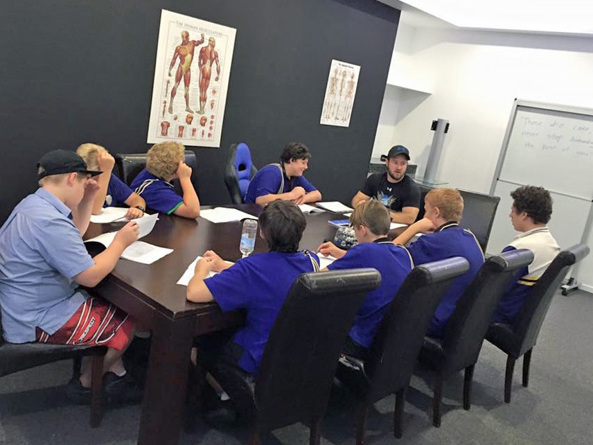 youths sit around boardroom type table