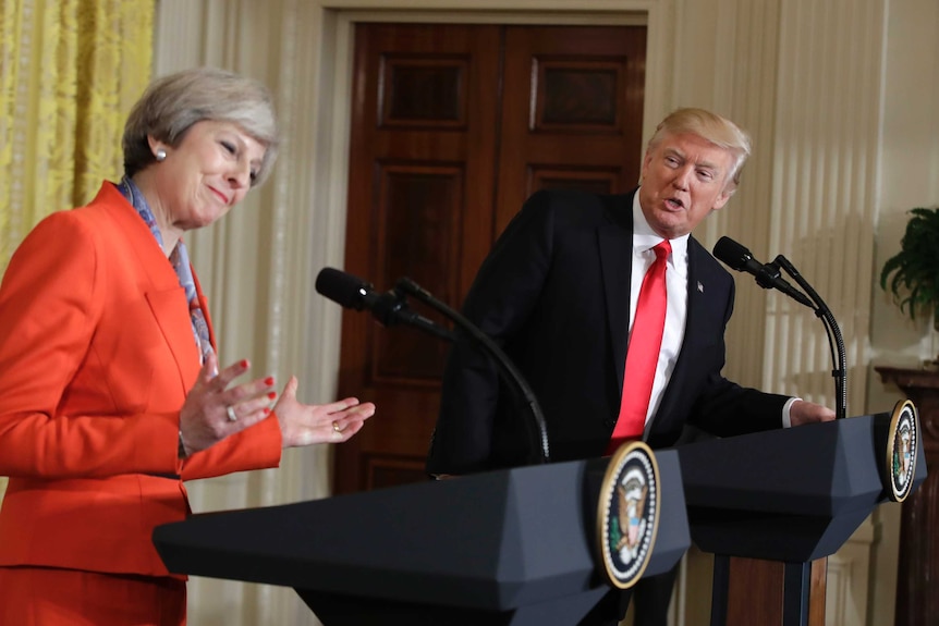 Theresa May smiles while speaking at a press conference with Donald Trump