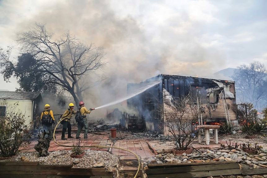 Firefighters battle flames at the Alpine Oaks Estates mobile home park during a wildfire.