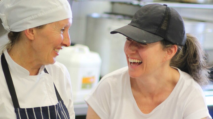 Natasha and her colleague in the kitchen preparing a chicken dish