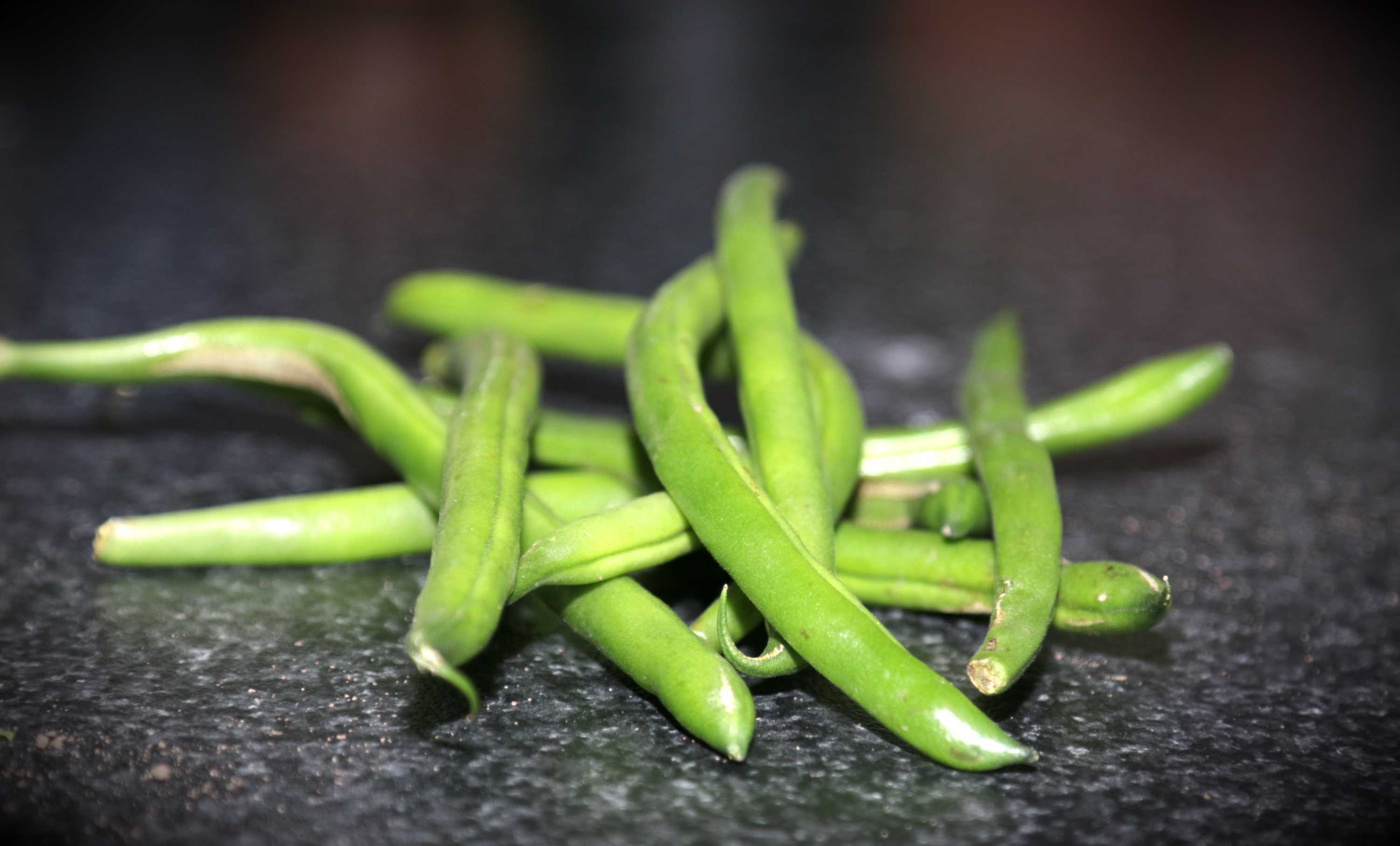 Green beans on a dark bench, representing a DIY vegetable garden that doesn't require a backyard.