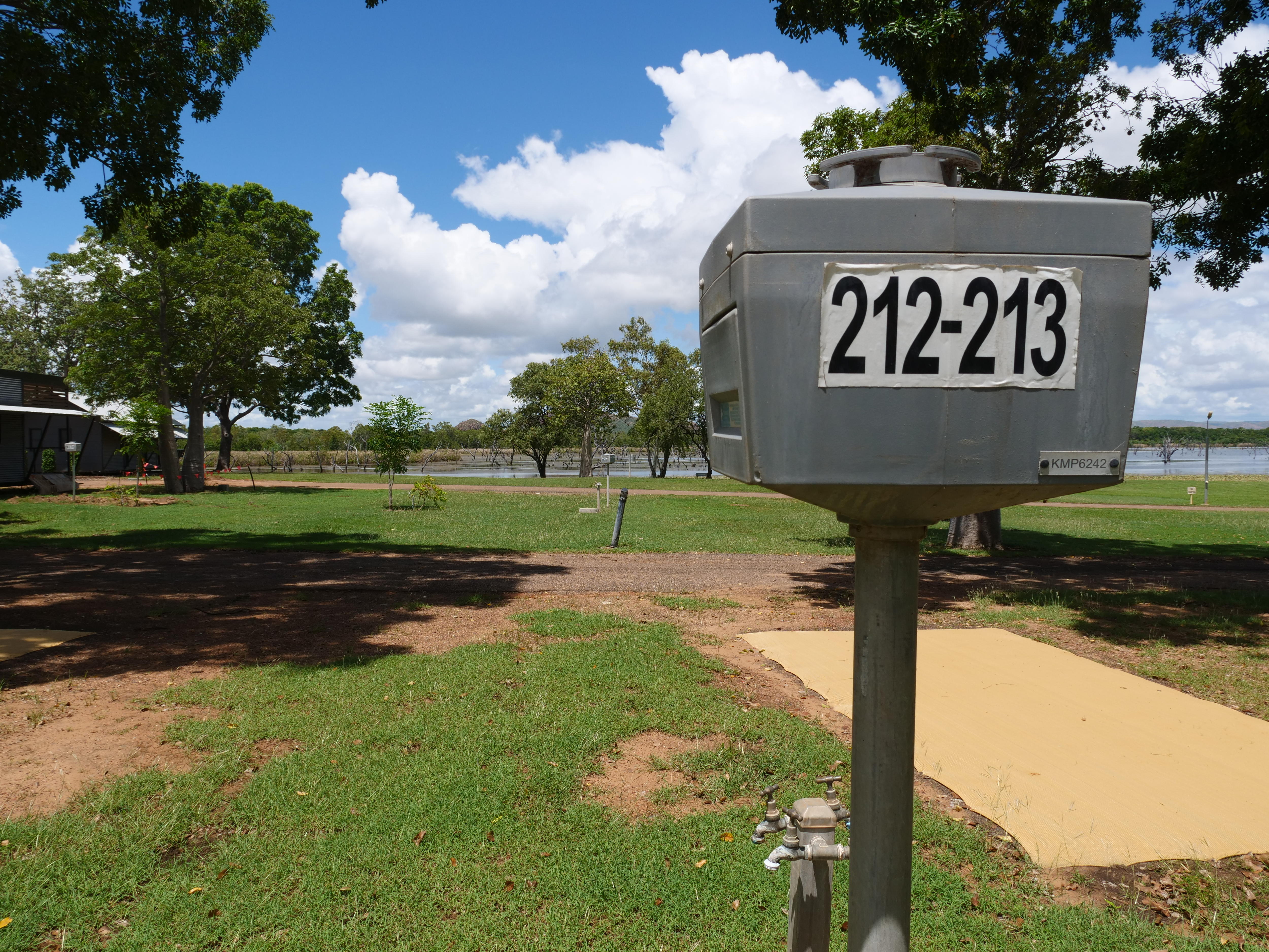 Empty caravan park sites by a lake.