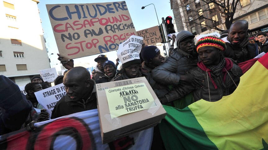 Demonstrators hold placards during an anti-racist demonstration in Milan