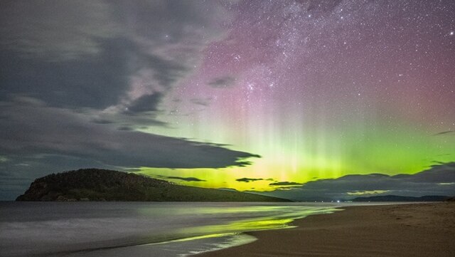 Green lights of the Aurora Australis beam into the night sky at South Arm, Tasmania.