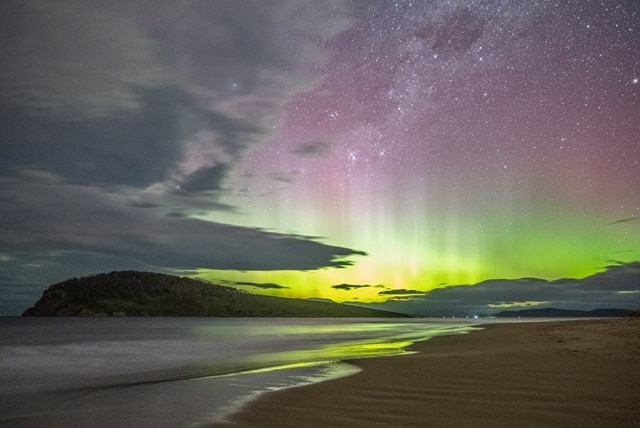Green lights of the Aurora Australis beam into the night sky at South Arm, Tasmania.