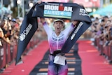 Sarah Crowley roars as she crosses the Ironman Cairns finish line