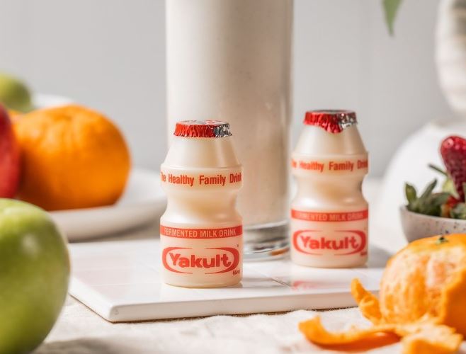 Two bottles of Yakult - the probiotic drink - posed on a kitchen table for a marketing photo