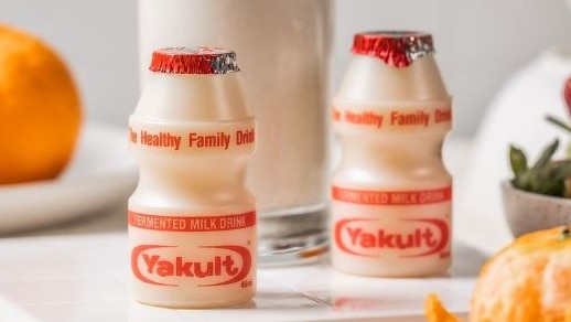 Two bottles of Yakult - the probiotic drink - posed on a kitchen table for a marketing photo